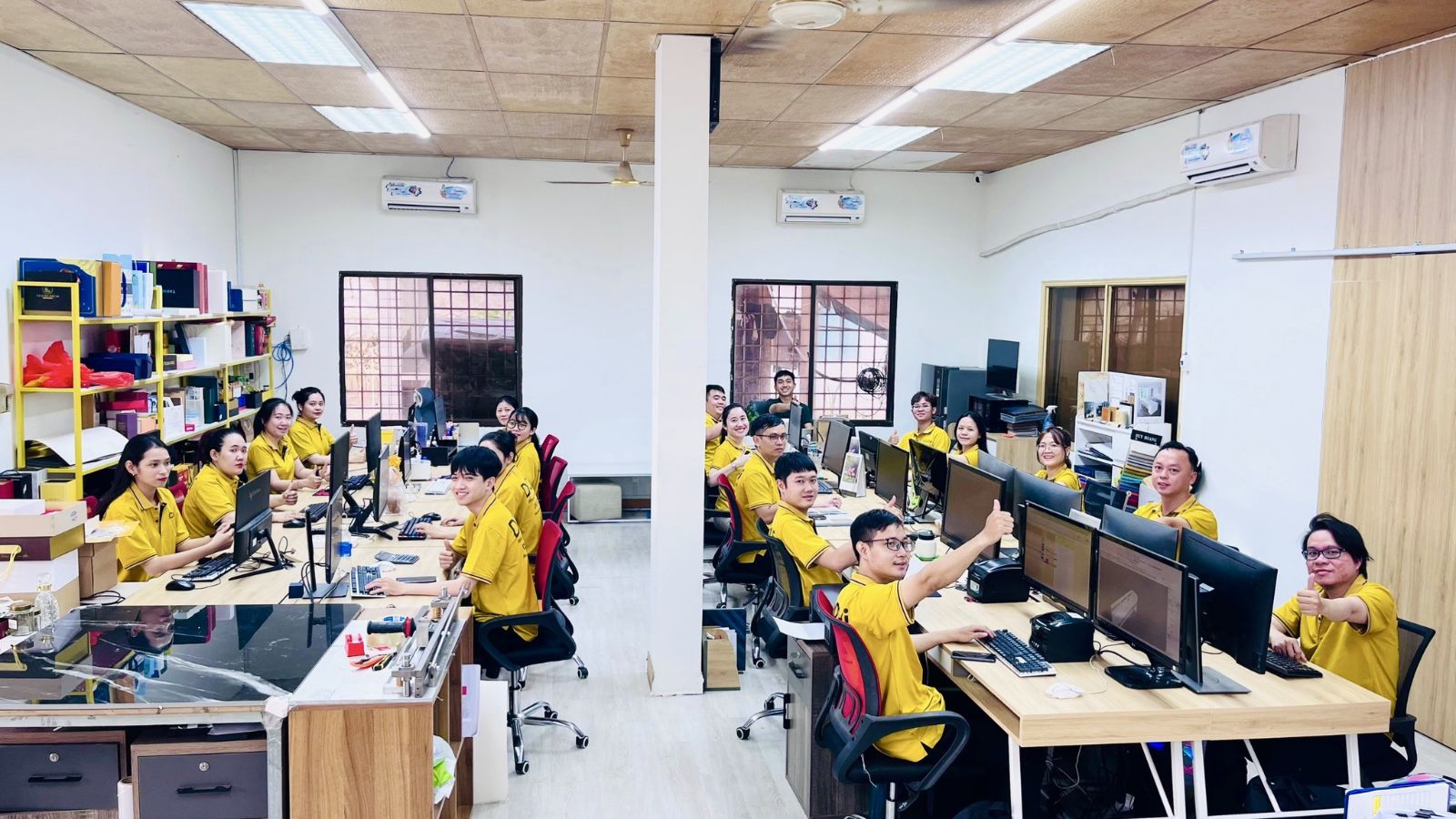 Top 5 Công Ty Thiết Kế Nội Thất Văn Phòng Đồng Nai Uy Tín 2026 8 Đội ngũ nhân viên thiết kế nội thất Dochi Office đồng phục vàng làm việc tại văn phòng chuyên nghiệp